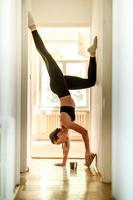 giovane donna fare handstand e lettura libro foto