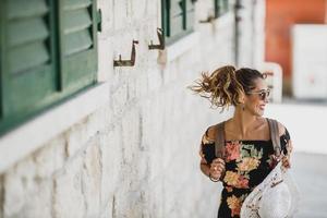 donna nel estate vestito andando per un' camminare attraverso vecchio mediterraneo città foto