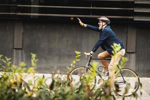 un' uomo d'affari in viaggio per opera con un' bicicletta foto