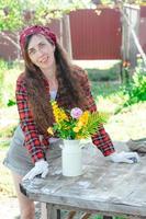 ritratto di un' sorridente contadino ragazza con un' mazzo di fiori su il strada foto