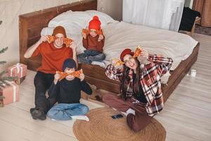 divertente famiglia foto con Due bambini mangiare Pizza nel letto. contento famiglia momento su il fine settimana. un' famiglia con Due bambini è mangiare un ordinato Pizza a partire dal un' scatola nel il Camera da letto. boho stile Camera da letto