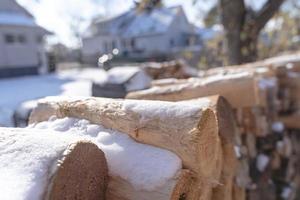 asciutto legna da ardere e neve nel il inverno, impilati nel il Giardino dietro la casa. foto