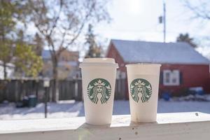 marinette,wi,usa - nov14, 2019- tazze di Starbucks caldo caffè mettere su bianca neve nel inverno giardino, fresco e caldo bevanda prendere lontano concept.starbucks bar caffè negozio. foto