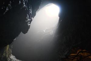 roccia grotta con buco attraverso quale leggero brilla. inferi nel Svezia. mistico foto