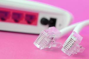 Internet router e Internet cavo spine menzogna su un' luminosa rosa sfondo. elementi necessario per Internet foto