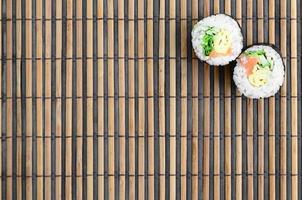 Sushi rotoli bugie su un' bambù cannuccia servire stuoia. tradizionale asiatico cibo. superiore Visualizza. piatto posare minimalismo tiro con copia spazio foto