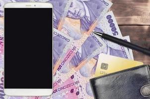 50000 rumeno leu fatture e smartphone con borsa e credito carta. pagamenti elettronici o e-commerce concetto. in linea shopping e attività commerciale con portatile dispositivi foto