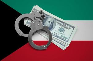 Kuwait bandiera con manette e un' fascio di dollari. moneta corruzione nel il nazione. finanziario crimini foto
