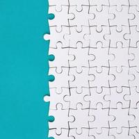 frammento di un' piegato bianca sega puzzle su il sfondo di un' blu plastica superficie. struttura foto con copia spazio per testo