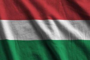 Ungheria bandiera con grande pieghe agitando vicino su sotto il studio leggero al chiuso. il ufficiale simboli e colori nel bandiera foto