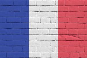 Francia bandiera raffigurato nel dipingere colori su vecchio mattone parete. strutturato bandiera su grande mattone parete opere murarie sfondo foto