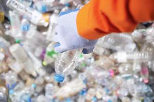 vicino su lavoratore mano con il separazione di plastica bottiglie raccolta differenziata industria foto