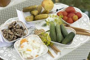 cibo su tavolo. sottaceti a partire dal giardino. cetrioli e pomodori su piatti. sostanzioso il pranzo. foto