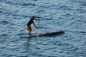 nuotatore su vacanza pagaia fare surf nel il mediterraneo mare foto