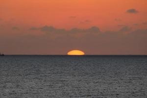 sole disco crescente al di sopra di il orizzonte di il mare, Alba, alba foto