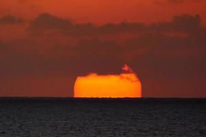 sole disco crescente al di sopra di il orizzonte di il mare, Alba, alba foto