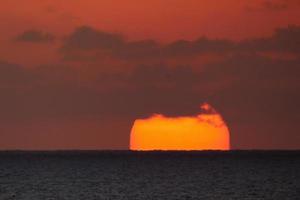 sole disco crescente al di sopra di il orizzonte di il mare, Alba, alba foto