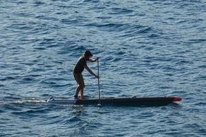 nuotatore su vacanza pagaia fare surf nel il mediterraneo mare foto