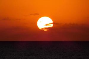 sole disco crescente al di sopra di il orizzonte di il mare, Alba, alba foto