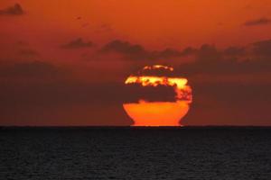 sole disco crescente al di sopra di il orizzonte di il mare, Alba, alba foto