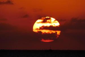 sole disco crescente al di sopra di il orizzonte di il mare, Alba, alba foto