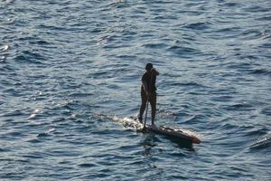 nuotatore su vacanza pagaia fare surf nel il mediterraneo mare foto