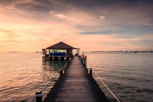 bar e di legno ponte nel il mare a il tramonto foto