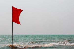 rosso bandiera su il oceano costa marcatura il inverso flusso arambol foto