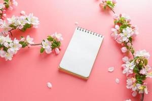 fioritura primavera sakura su un' rosa sfondo con bloc notes spazio per saluto Messaggio. il concetto di primavera e La madre di giorno. bellissimo delicato rosa ciliegia fiori nel primavera foto