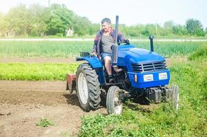 un' contadino unità un' trattore mentre Lavorando su un' azienda agricola campo. allentamento superficie, coltivando il terra. agricoltura, agricoltura. campo preparazione. uso di agricolo macchinari e attrezzatura per velocità su opera. foto