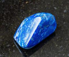 caduto lapis lazuli lazurite roccia su nero foto