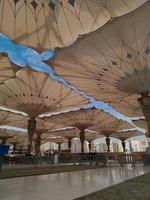 medina, Arabia arabia, 2022 - ombrello costruzione su il piazza di al-masjid an-nabawi o profeta muhammed moschea siamo proteggere persone a partire dal sole a giorno e opera come luci a notte foto