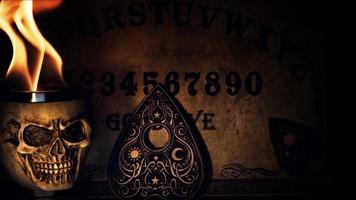 ouija strega tavola e cranio testa su fuoco foto