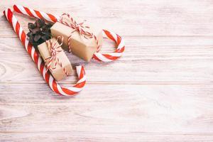 caramella canne e Natale regalo su Marrone di legno sfondo. tonica foto
