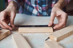 falegname mani assunzione misurazione con un' matita di di legno tavola. foto