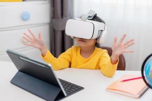 asiatico bambino con virtuale realtà, vr, ragazzo esplorando digitale virtuale mondo con vr occhiali. foto