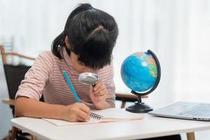 la bambina asiatica sta imparando il modello del globo, il concetto di salvare il mondo e imparare attraverso l'attività di gioco per l'educazione dei bambini a casa. foto