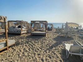 molti lettini e tettoie su un' sabbioso spiaggia con un' montagna e mare nel un' caldo tropicale orientale nazione meridionale ricorrere foto