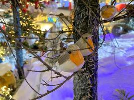 Natale albero decorazione. giocattolo uccello si siede om un' ramo albero nel un' Fata foresta su sfocato Natale sfondo. il concetto di nuovo anno e Natale. festivo decorazione foto