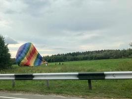 soffiato giù sgonfiare un' di grandi dimensioni, colorato, colorato, il giro, arcobaleno colorato, a strisce, volante Palloncino. il sfondo foto