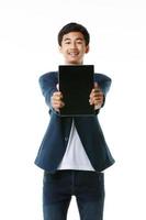 asiatico maschio junior alto scuola alunno 15 anni vecchio Tenere e mostrando vuoto schermo di tavoletta computer. moderno adolescente vita concetto e tecnologia. foto