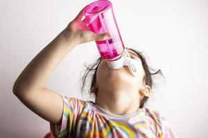 poco ragazza potabile acqua a partire dal risorto bottiglia foto