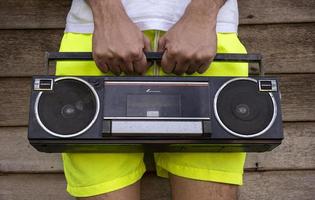 uomo indossare giallo pantaloni Tenere un vecchio Radio foto