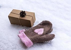 regalo nel mestiere scatola decorato con pino cono su bianca neve e guanti con rosa cuore, eco amichevole eco concetto allegro Natale e nuovo anno foto