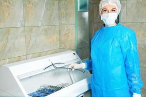 bellissimo giovane donna medico prende sterile elementi necessario per operazione foto