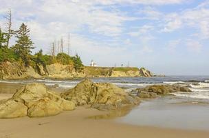 faro su un' aspro costiero spiaggia foto