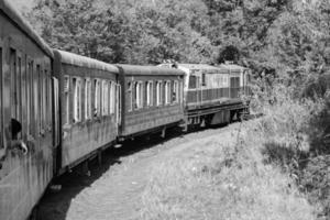 giocattolo treno in movimento su montagna pendenza, bellissimo Visualizza, uno lato montagna, uno lato valle in movimento su ferrovia per il collina, tra verde naturale foresta.giocattolo treno a partire dal calca per shimla nel nero indiano e bianca foto