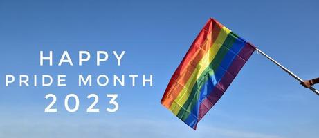 'felice orgoglio mese' su cielo blu e arcobaleno bandiere sfondo, concetto per lgbtqai celebrazioni nel orgoglio mese, giugno, 2023. foto