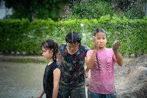 poco ragazze avere divertimento giocando nel il fango nel il Comunità i campi foto