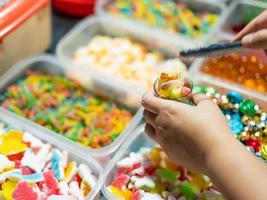 dolci siamo venduto nel scatole e piccolo cesti di gelatina caramelle di vario colori. acquirenti siamo raccolta su occhiali. foto